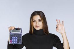 Mujer muestra una calculadora con su mano derecha, mientras con la izquierda realiza gesto de aprobación