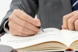 persona escribiendo en una mesa con un mazo persona escribiendo en una mesa con un mazo
