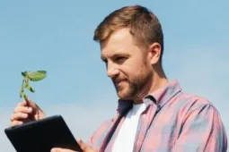 Hombre revisando tablet en campo Especialización en Suelos y Nutrición Vegetal