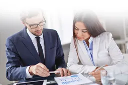 Especialización en Gestión Tributaria Dos personas revisando gráfico