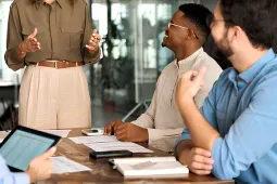 Ejecutiva dando un charla a dos personas de su equipo