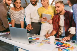 Grupo de personas colaborando en una reunión de trabajo alrededor de una mesa