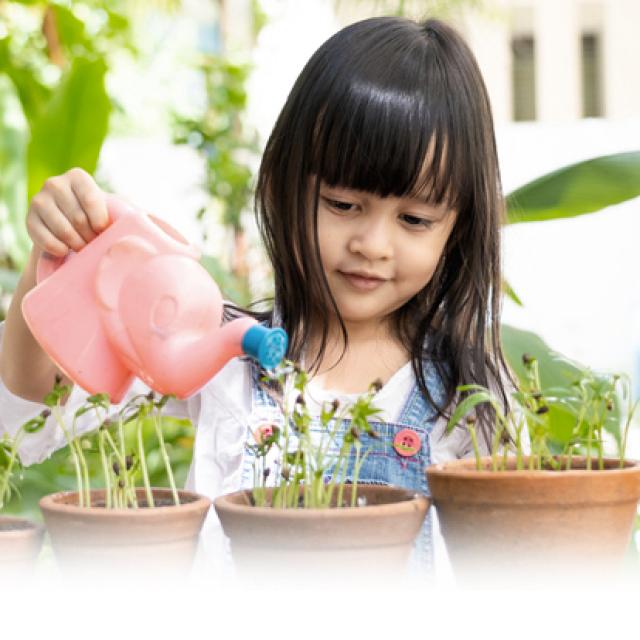 niña regando plantas