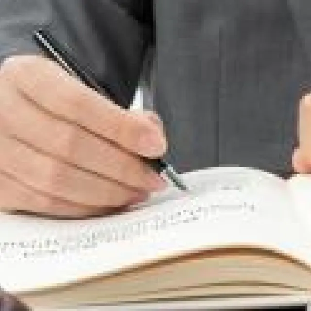 persona escribiendo en una mesa con un mazo