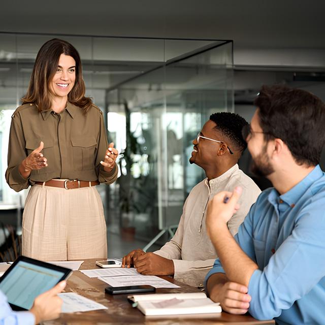 Ejecutiva dando un charla a dos personas de su equipo