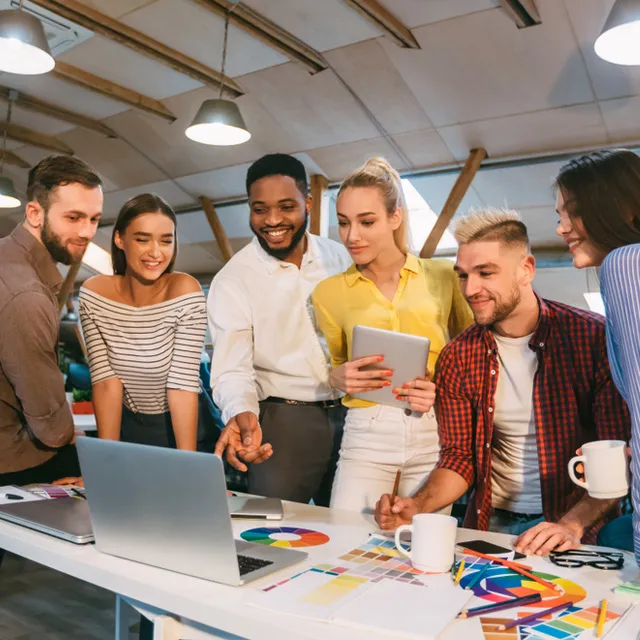 Grupo de personas colaborando en una reunión de trabajo alrededor de una mesa