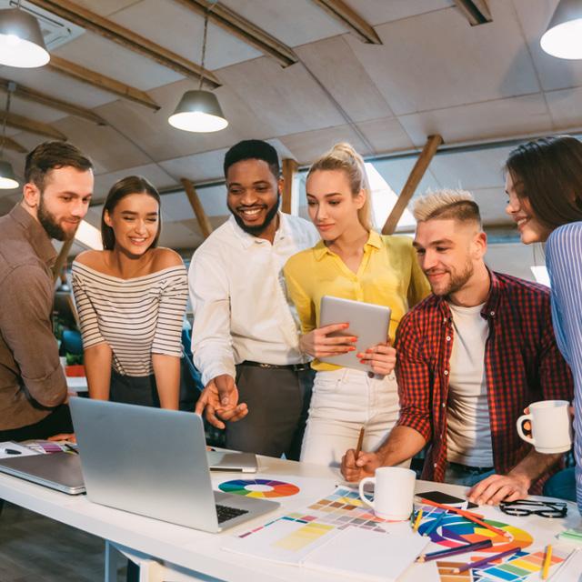 Grupo de personas colaborando en una reunión de trabajo alrededor de una mesa