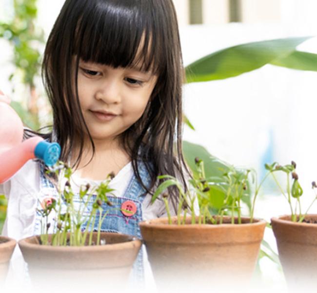 niña regando plantas