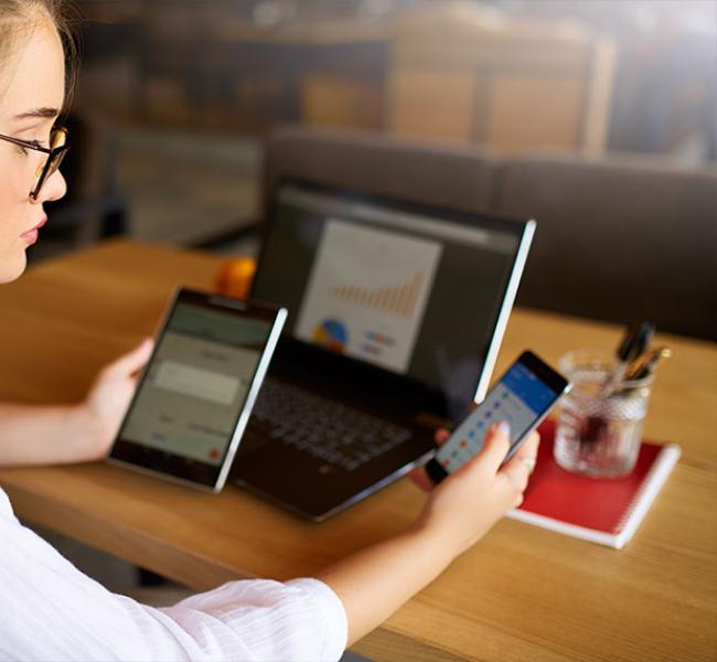 mujer-revisando-celular-y-computador