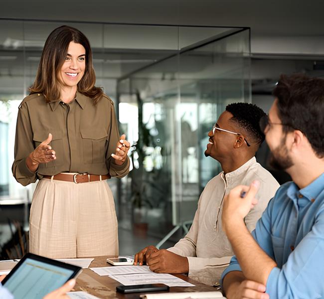 Ejecutiva dando un charla a dos personas de su equipo